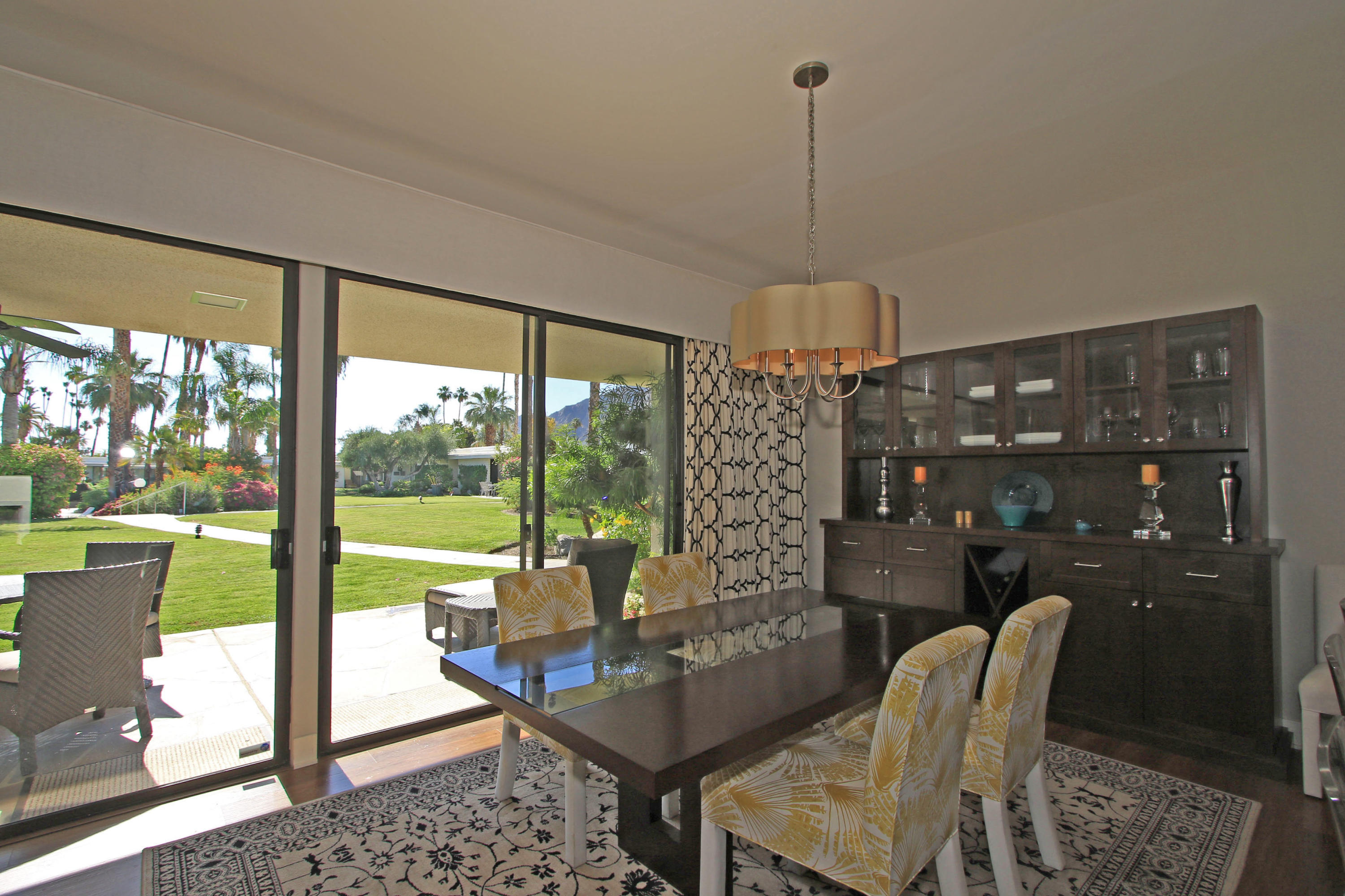 45760 Pawnee Road Indian Wells, CA 92210 - Photo 22 of 56 a living room with furniture a lamp and a floor to ceiling window