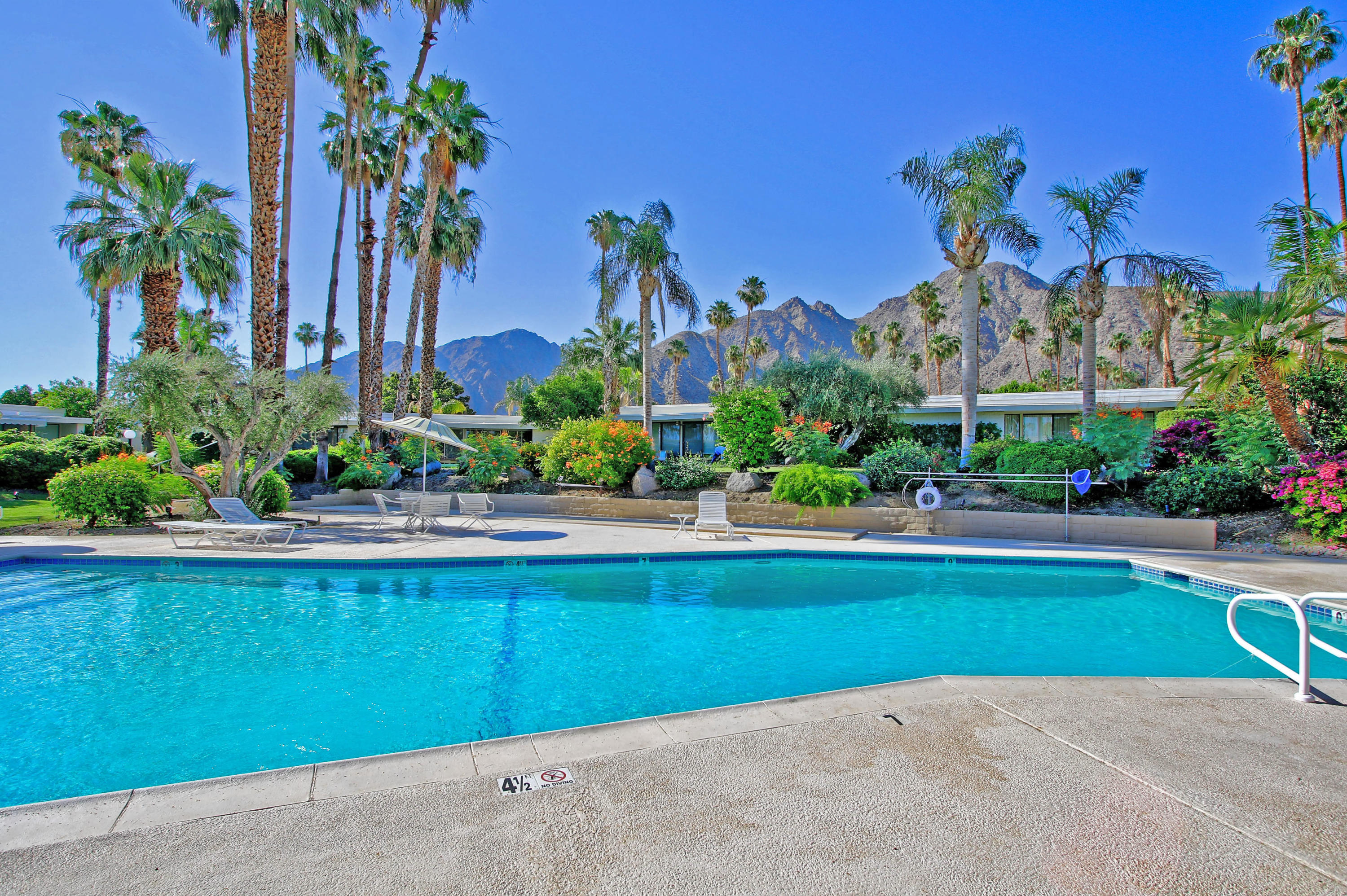 45760 Pawnee Road Indian Wells, CA 92210 - Photo 54 of 56 a view of a house with a swimming pool and a yard