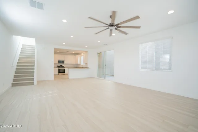 an empty room with closet and a ceiling fan