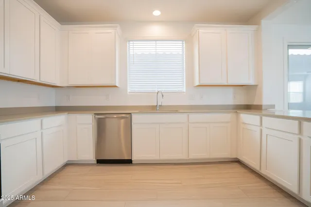a kitchen with white cabinets and white appliances