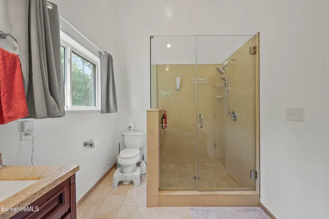a spacious bathroom with a granite countertop sink mirror and a toilet