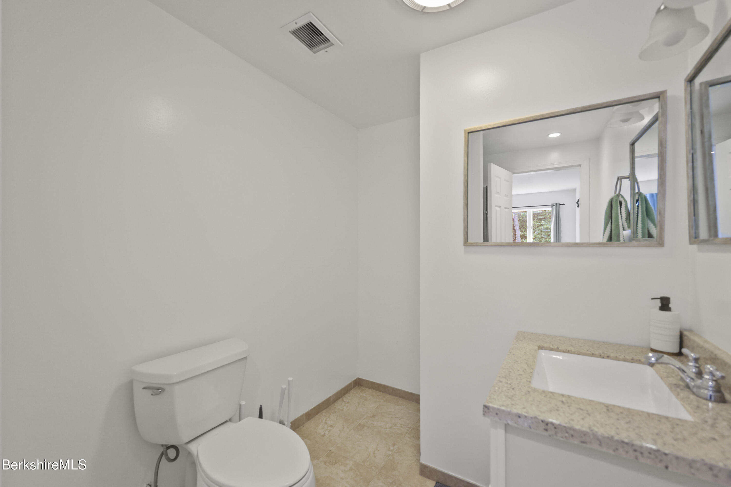 674 Benton Hill Road Becket, MA 01223 - Photo 54 of 61 a bathroom with a toilet sink vanity and mirror
