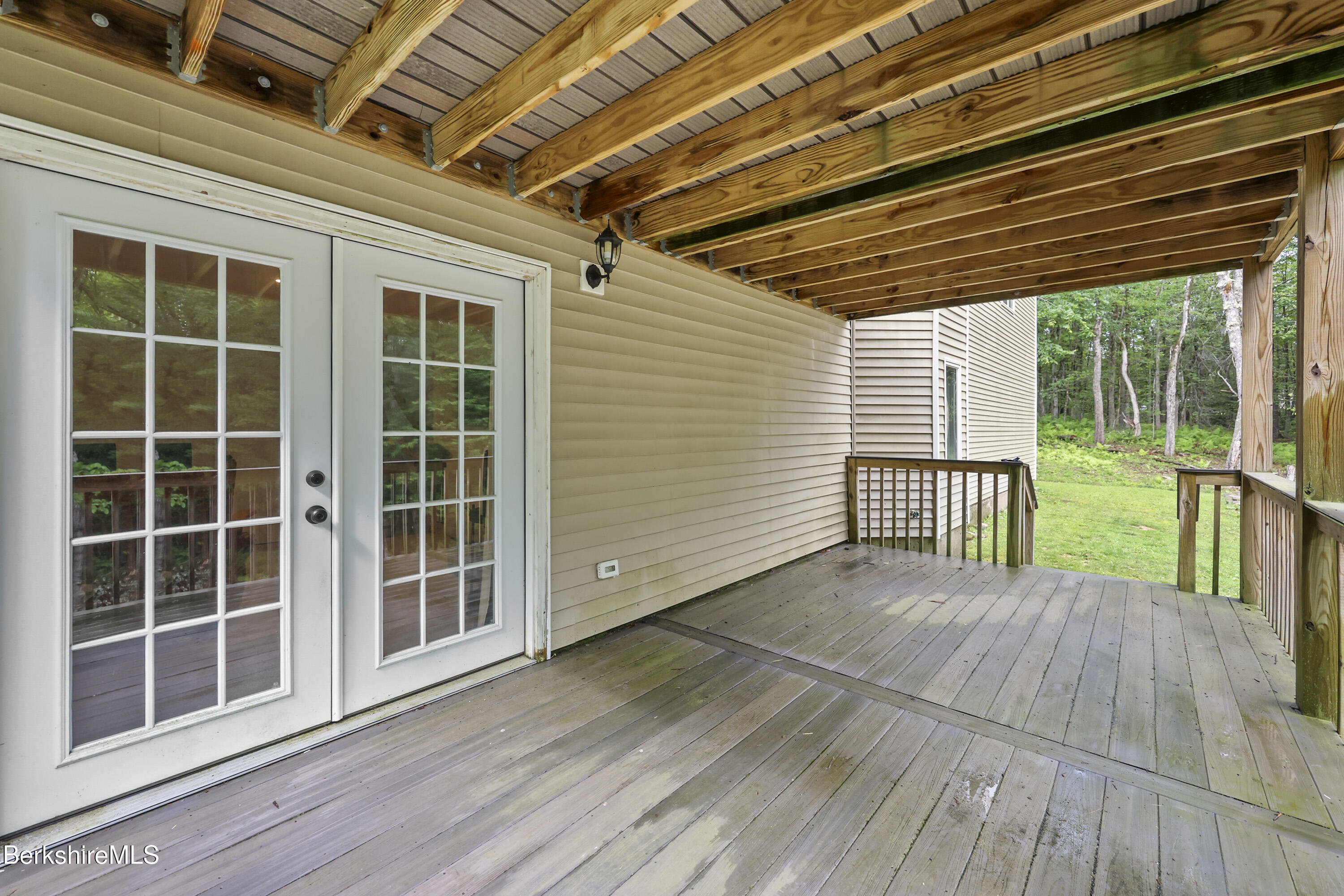 674 Benton Hill Road Becket, MA 01223 - Photo 58 of 61 a view of a backyard with wooden floor and floor to ceiling window
