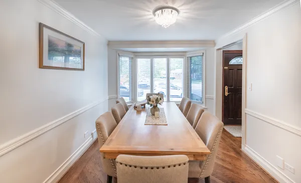a view of a dining room with furniture a chandelier and wooden floor