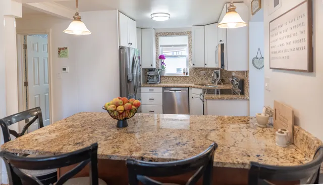 a kitchen with stainless steel appliances kitchen island granite countertop a sink and refrigerator