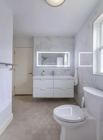 a bathroom with a toilet a sink and mirror