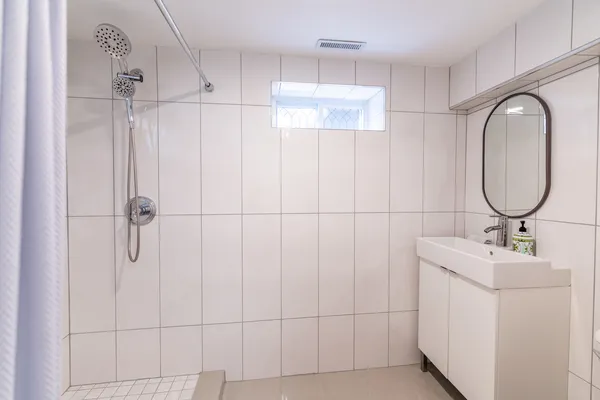 a bathroom with a double vanity sink a mirror and a shower
