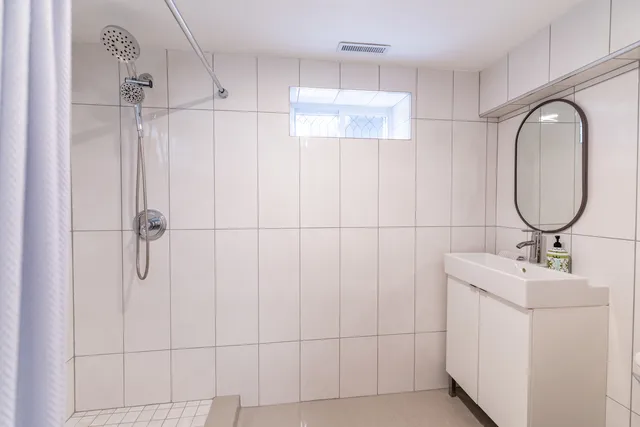 a bathroom with a double vanity sink a mirror and a shower
