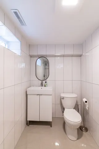 a bathroom with a toilet a sink and a mirror
