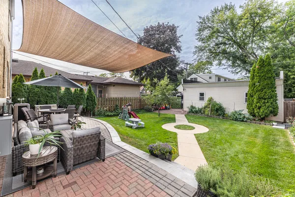 a view of a patio with couches and a table and chairs with plants and trees