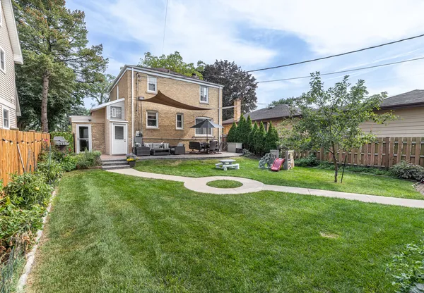 a view of a house with a big yard and large trees