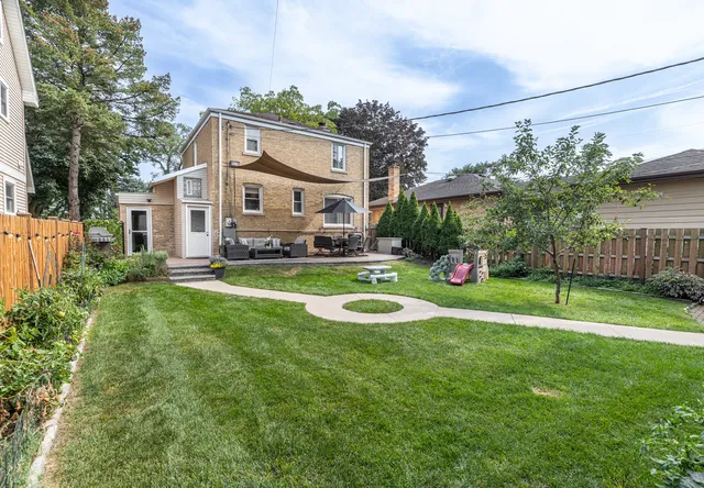 a view of a house with a big yard and large trees