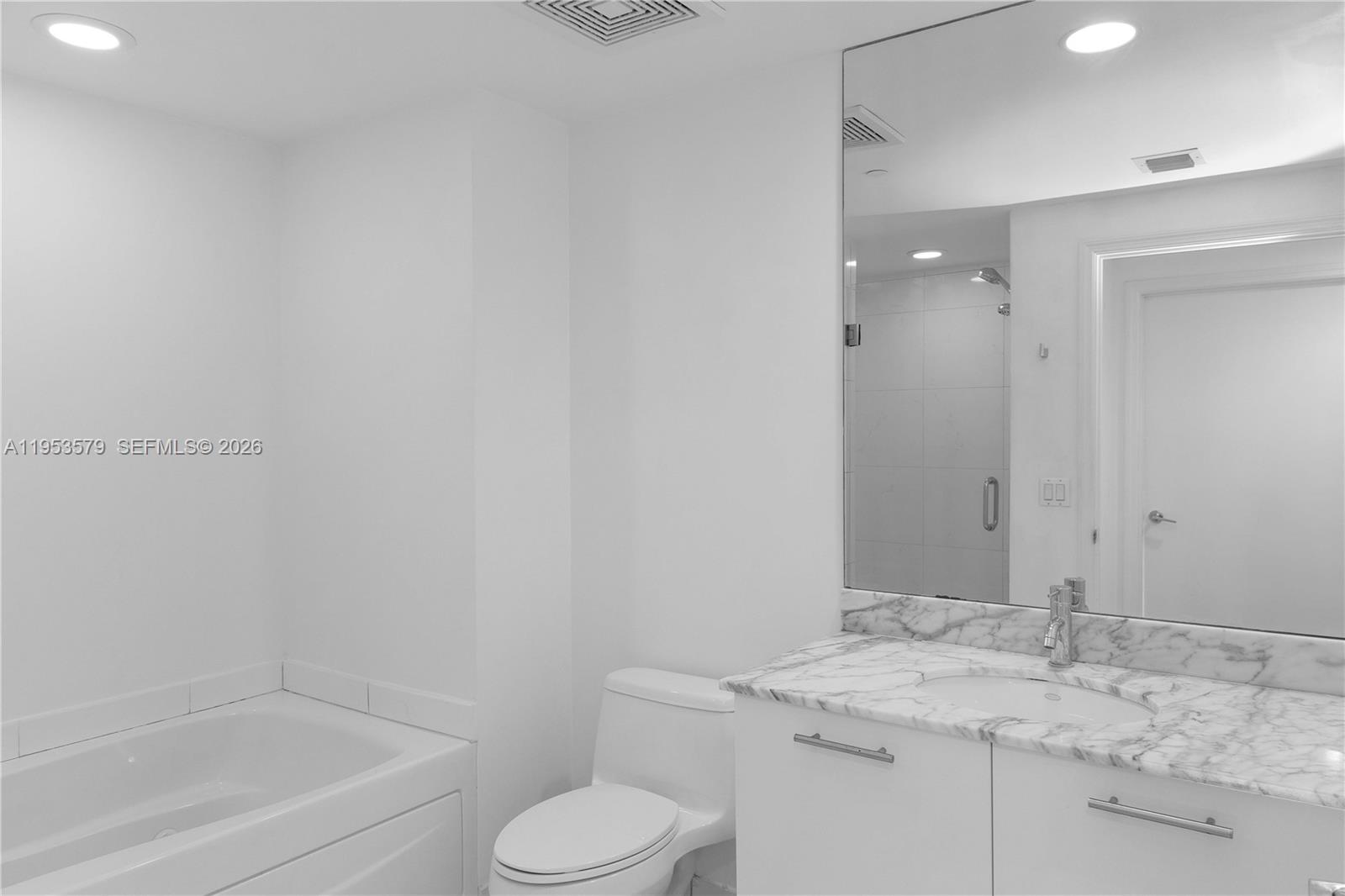 55 Southeast 6th Street, Unit 2606 Miami, FL 33131 - Photo 13 of 18 a bathroom with a granite countertop sink toilet and shower