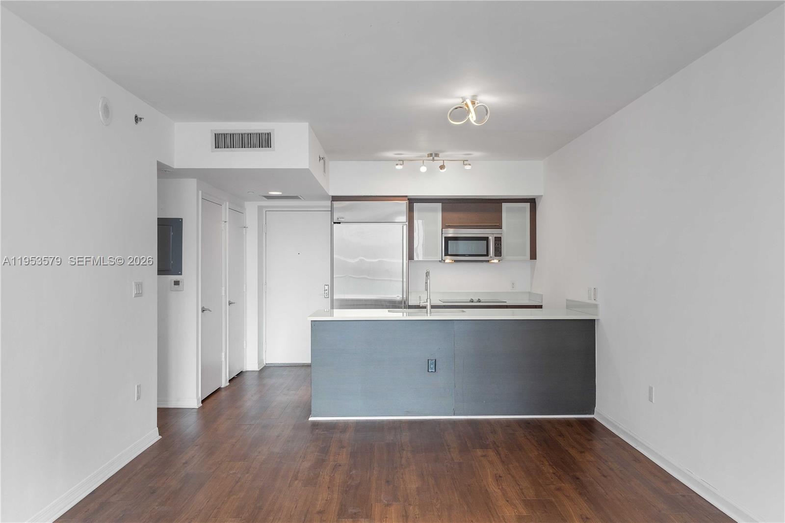 55 Southeast 6th Street, Unit 2606 Miami, FL 33131 - Photo 3 of 18 a view with kitchen island wooden floors and refrigerator