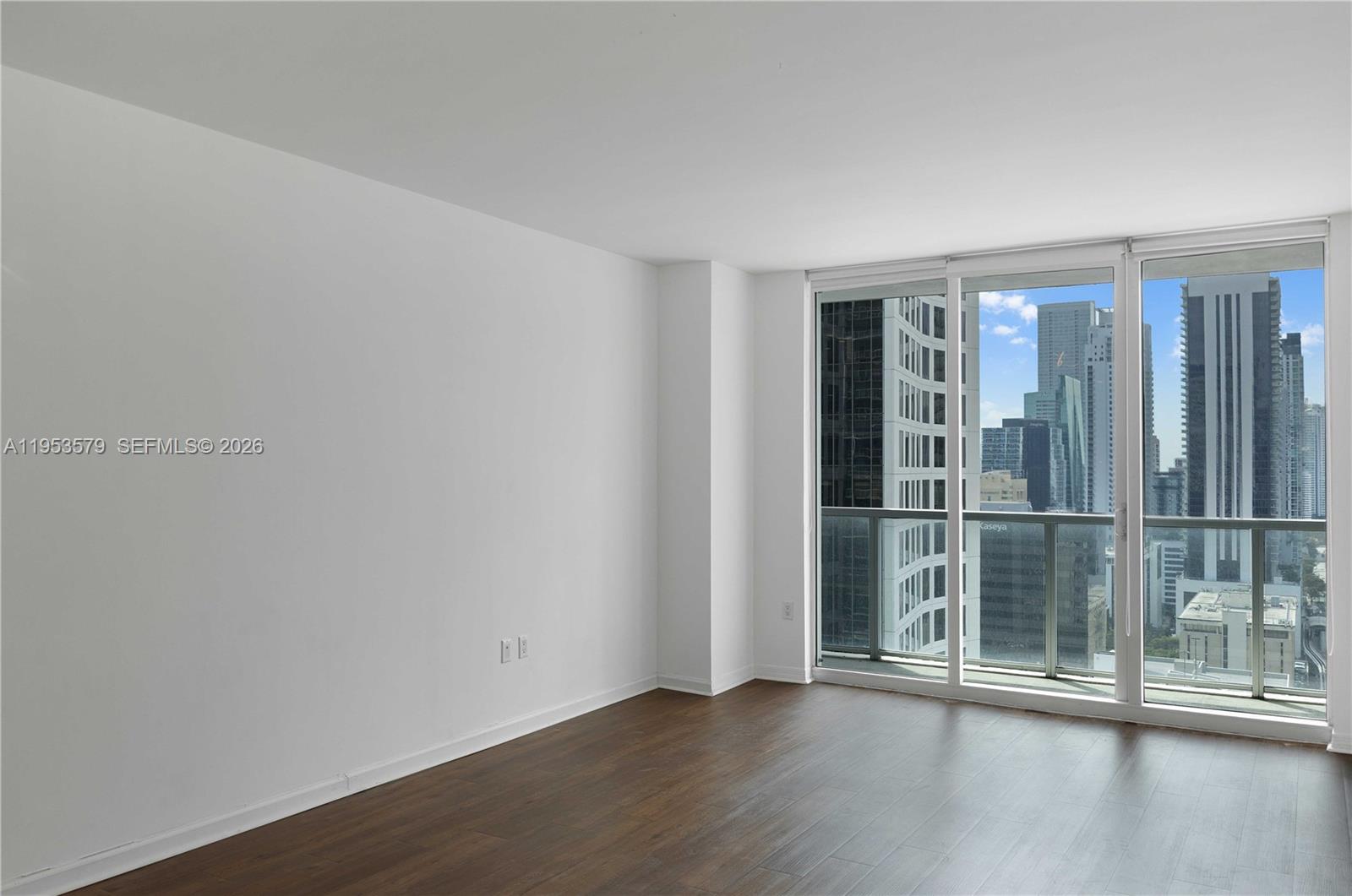 55 Southeast 6th Street, Unit 2606 Miami, FL 33131 - Photo 5 of 18 an empty room with wooden floor and windows