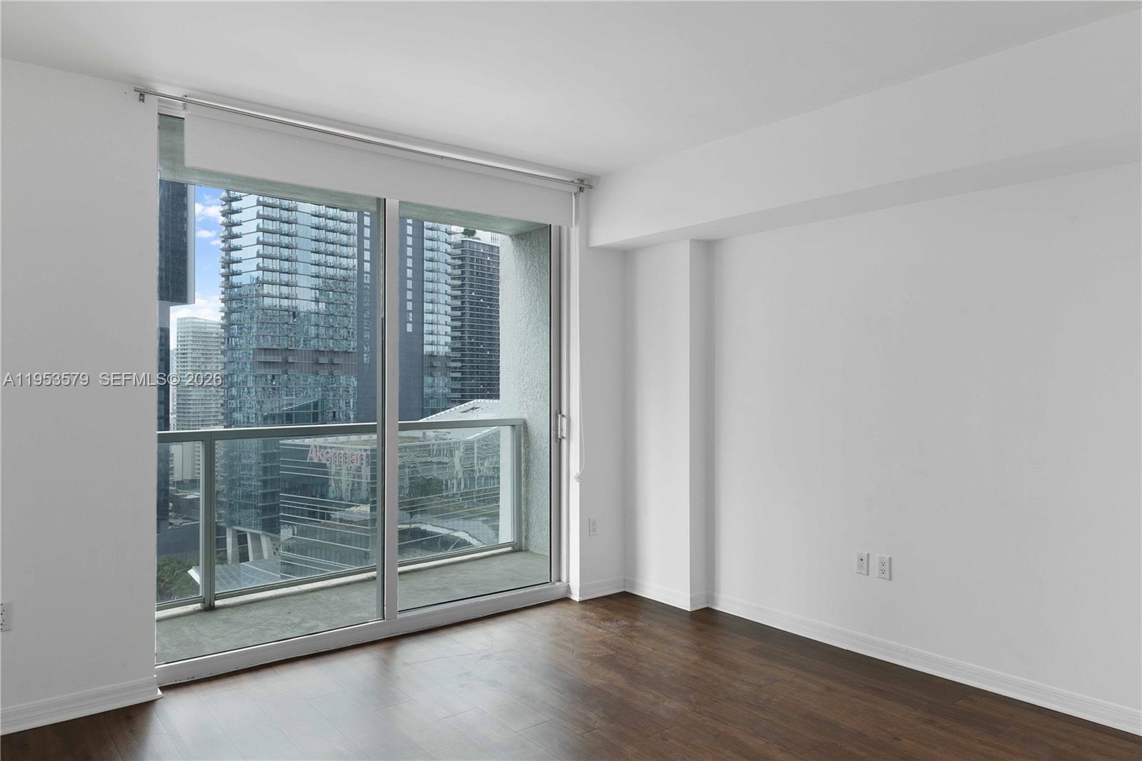 55 Southeast 6th Street, Unit 2606 Miami, FL 33131 - Photo 10 of 18 a view of a room with wooden floor and sliding glass door