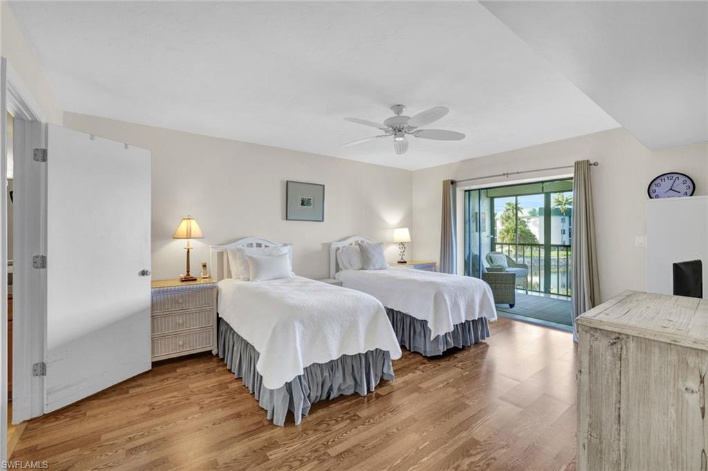 855 Ketch Drive, Unit 206 Naples, FL 34103 - Photo 7 of 17 Bedroom with wood finished floors, access to exterior, and ceiling fan