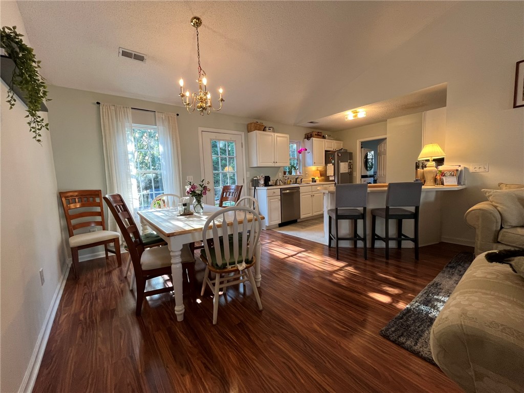 116 Arbors Court Central, SC 29630 - Photo 11 of 27 Rich hardwood flooring stretches across an open-concept layout, connecting the dining area to a well-appointed kitchen.
