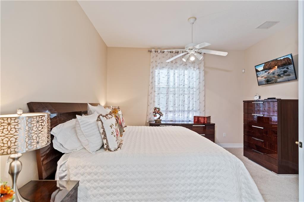 1915 Bridgepointe Circle, Unit 41 Vero Beach, FL 32967 - Photo 11 of 36 a bedroom with a bed and a tv on the dresser