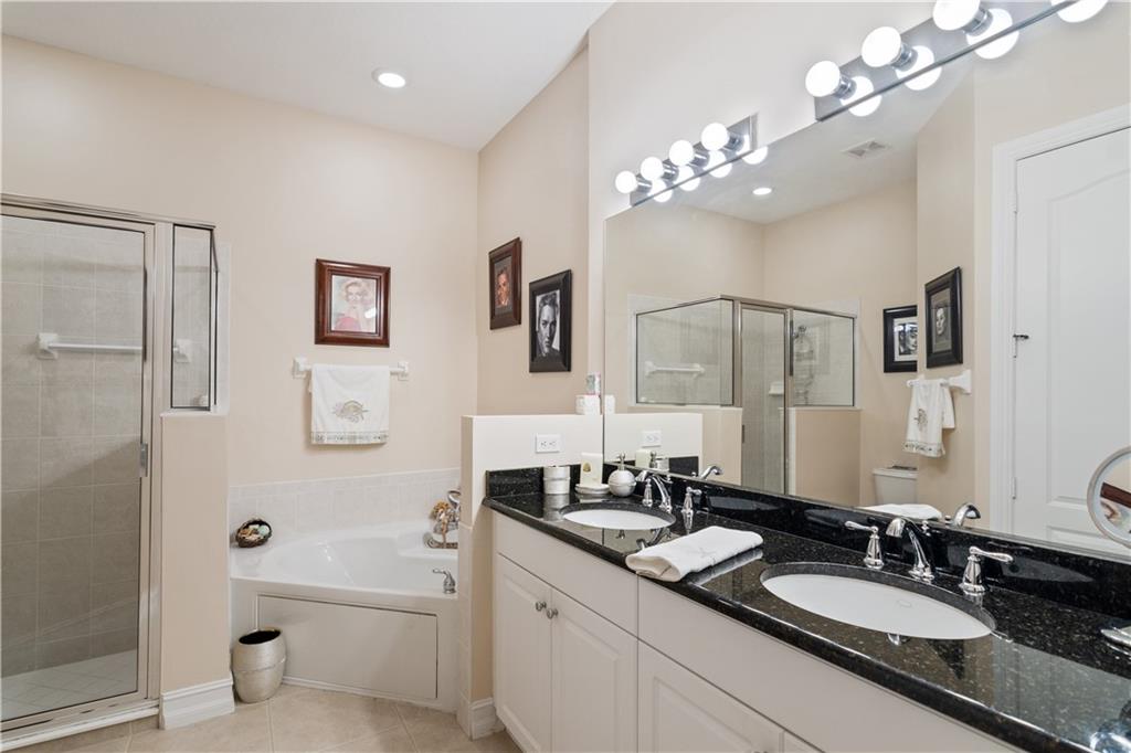 1915 Bridgepointe Circle, Unit 41 Vero Beach, FL 32967 - Photo 12 of 36 a bathroom with a granite countertop sink a toilet a large mirror and shower