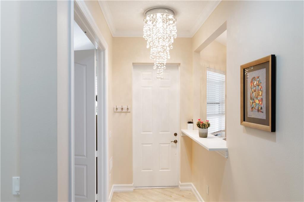 1915 Bridgepointe Circle, Unit 41 Vero Beach, FL 32967 - Photo 15 of 36 a view of a hallway with a white cabinet a mirror and a window