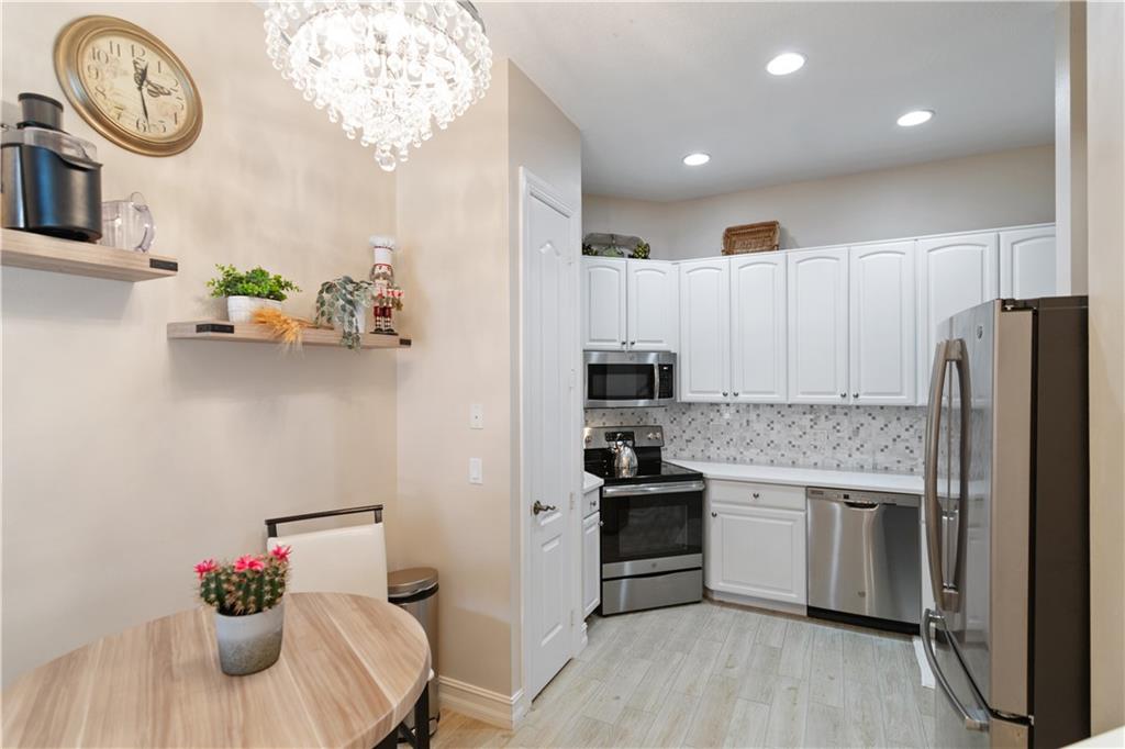 1915 Bridgepointe Circle, Unit 41 Vero Beach, FL 32967 - Photo 25 of 36 a kitchen with white cabinets and stainless steel appliances