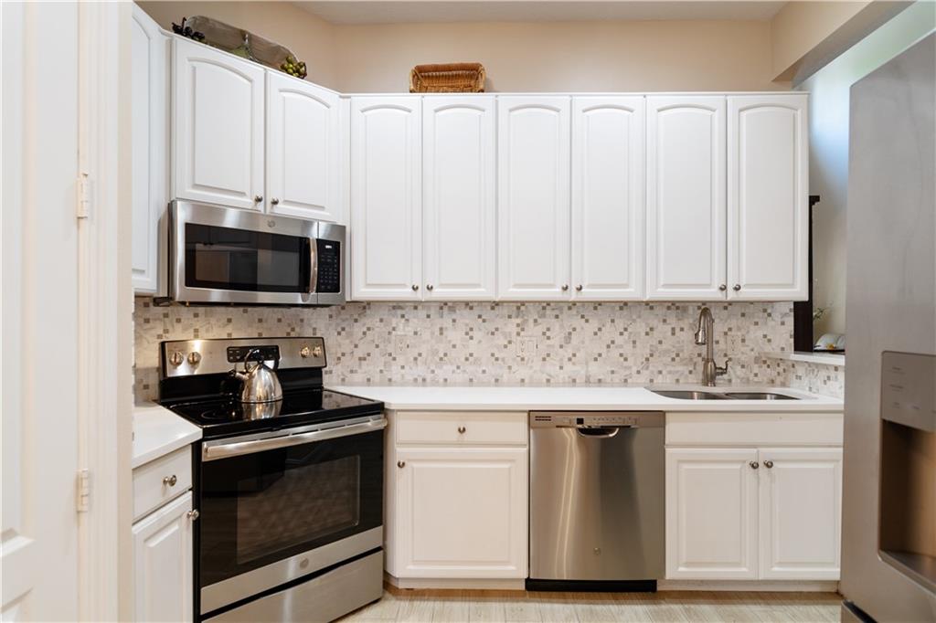 1915 Bridgepointe Circle, Unit 41 Vero Beach, FL 32967 - Photo 26 of 36 a kitchen with stainless steel appliances granite countertop a stove a microwave and a refrigerator