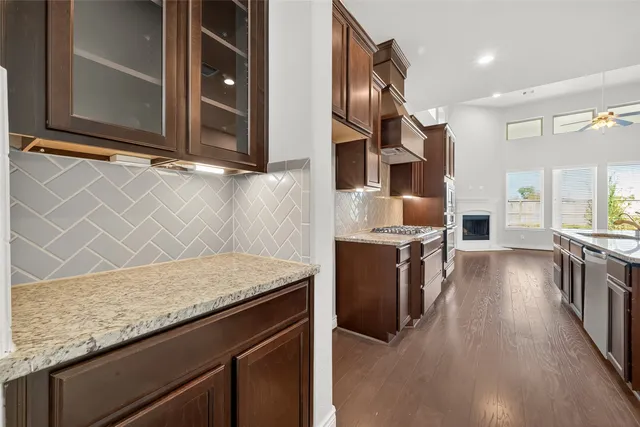 a kitchen with stainless steel appliances granite countertop a stove a sink and a microwave