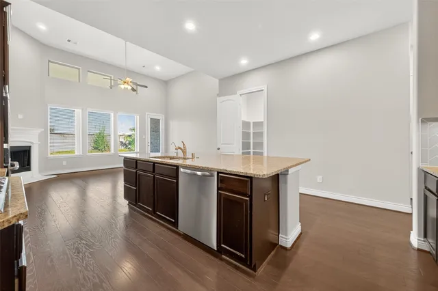 a kitchen with stainless steel appliances granite countertop a stove and a wooden floors