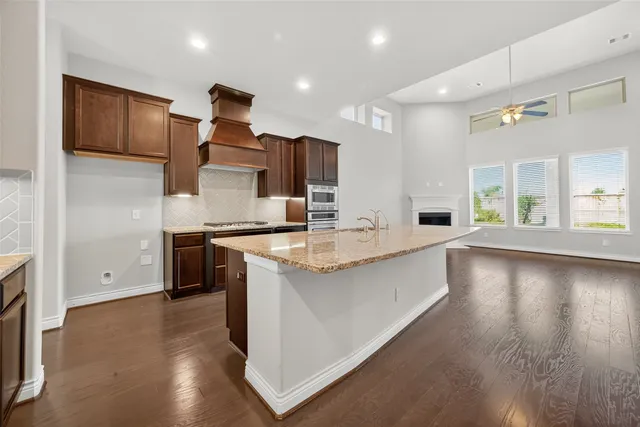 a kitchen with stainless steel appliances granite countertop a sink and a stove top oven