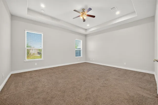 an empty room with a window and a ceiling fan