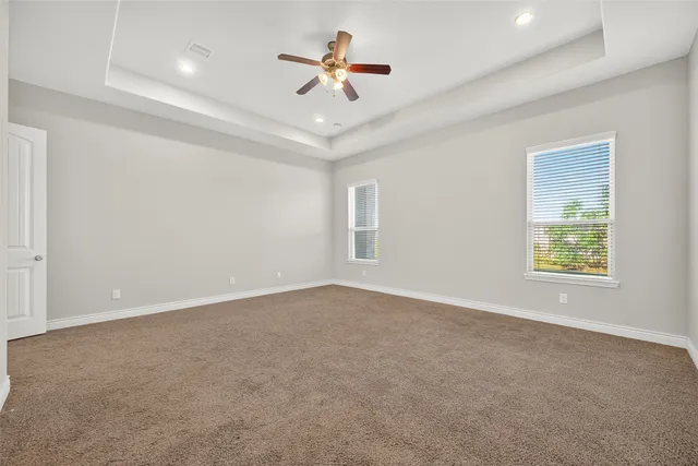 an empty room with ceiling fan and window