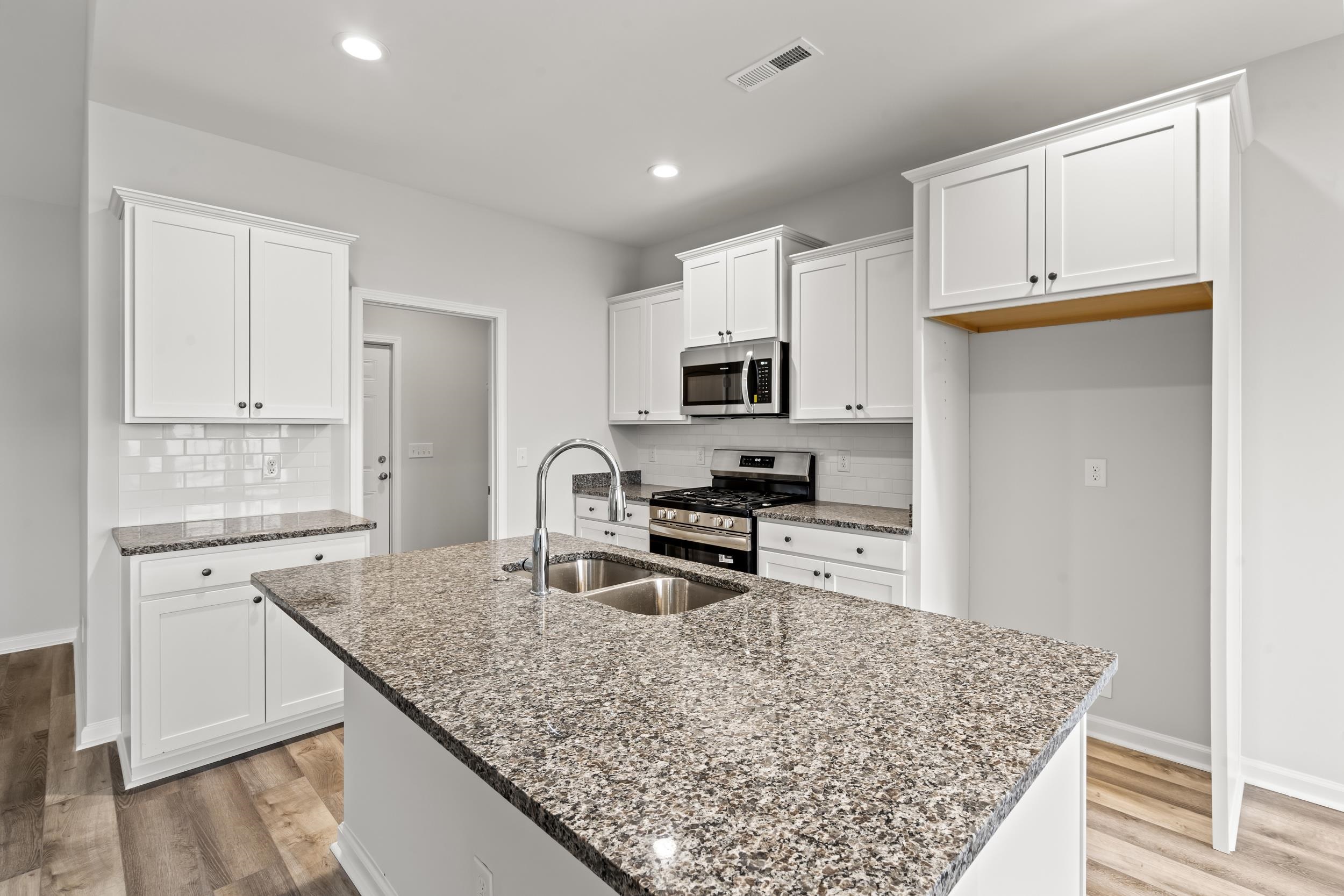 231 Stillbrook Drive Longs, SC 29568 - Photo 5 of 38 Kitchen featuring stainless steel appliances, white cabinets, dark stone counters, light wood-type flooring, and decorative backsplash