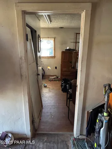 a view of a hallway with wooden floor and a livingroom view