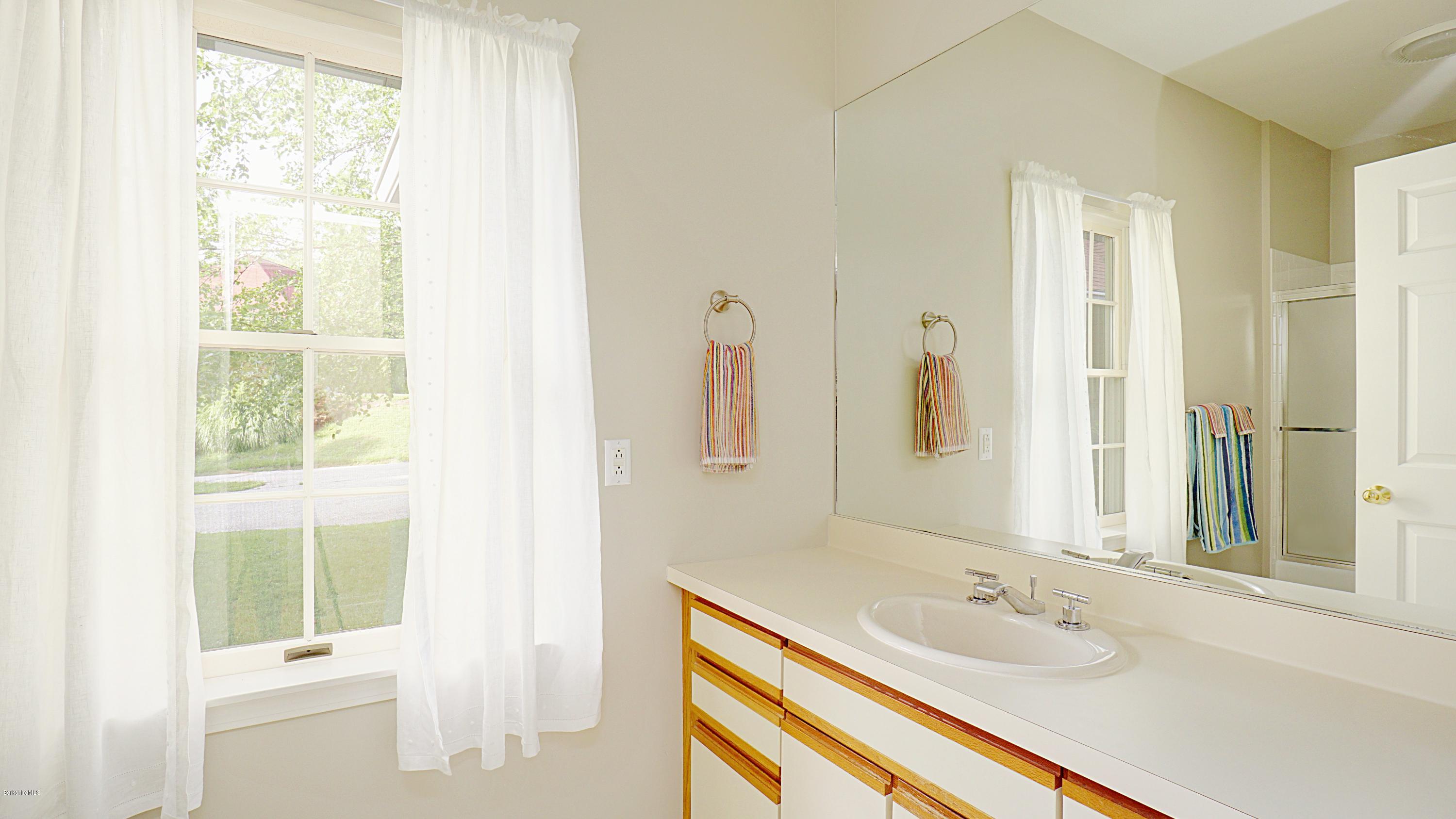 11 Prospect Hill Road, Unit 3 Stockbridge, MA 01262 - Photo 16 of 27 a bathroom with a granite countertop sink and a mirror