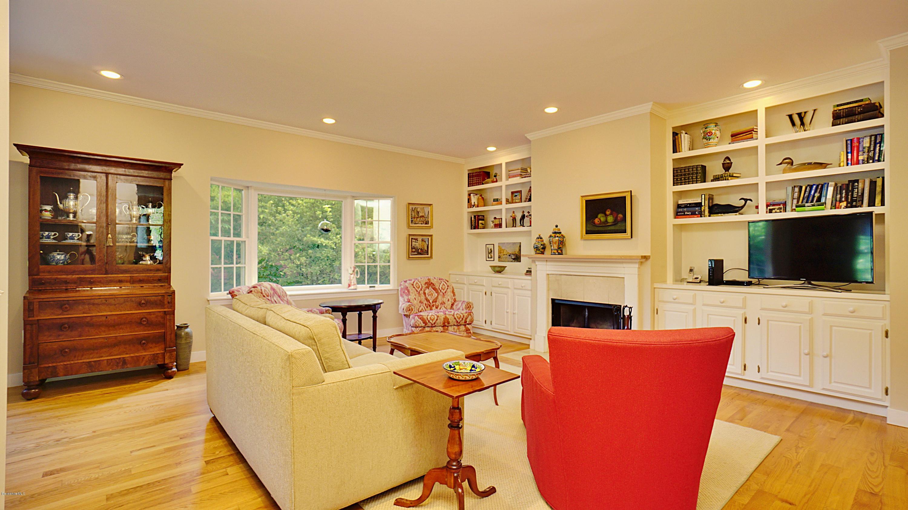 11 Prospect Hill Road, Unit 3 Stockbridge, MA 01262 - Photo 5 of 27 a living room with furniture a fireplace and a flat screen tv
