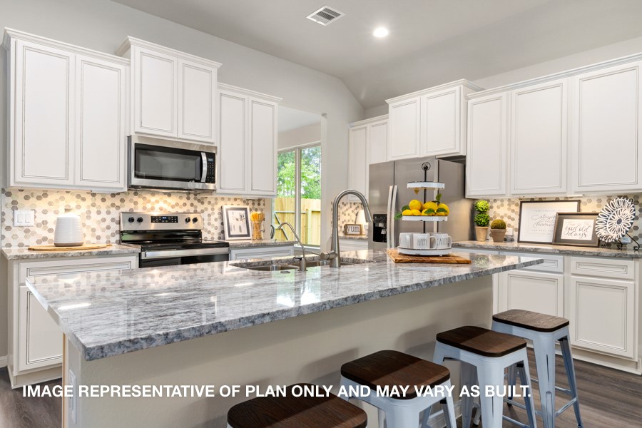 1421 Imperial Ranch Way Dayton, TX 77535 - Photo 2 of 19 a kitchen with granite countertop a stove a sink and a microwave