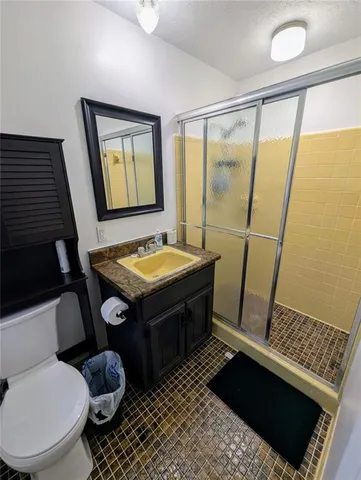 a bathroom with a sink a toilet a mirror and shower