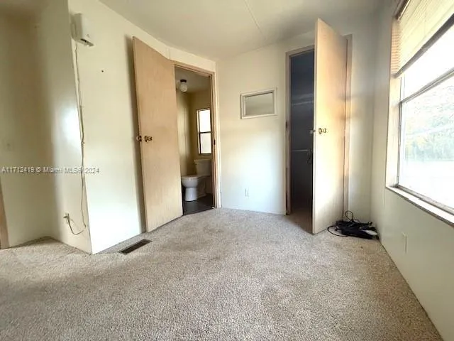 a view of empty room with windows and refrigerator