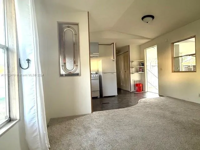a view of a room with window and refrigerator