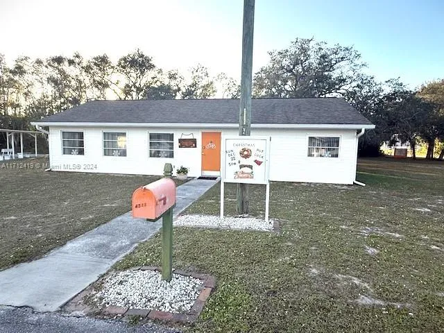 a view of a house with backyard and sitting area