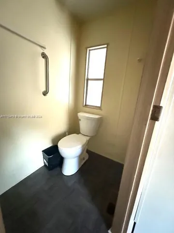 a white toilet sitting next to a bathroom sink and a window