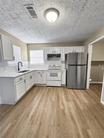a kitchen with a refrigerator a white stove top oven and a refrigerator
