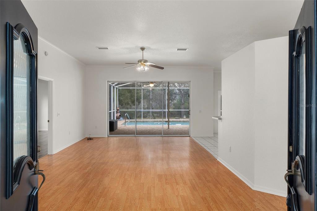 2214 Meadow Lark Road Spring Hill, FL 34608 - Photo 3 of 49 a view of an empty room with wooden floor and a window