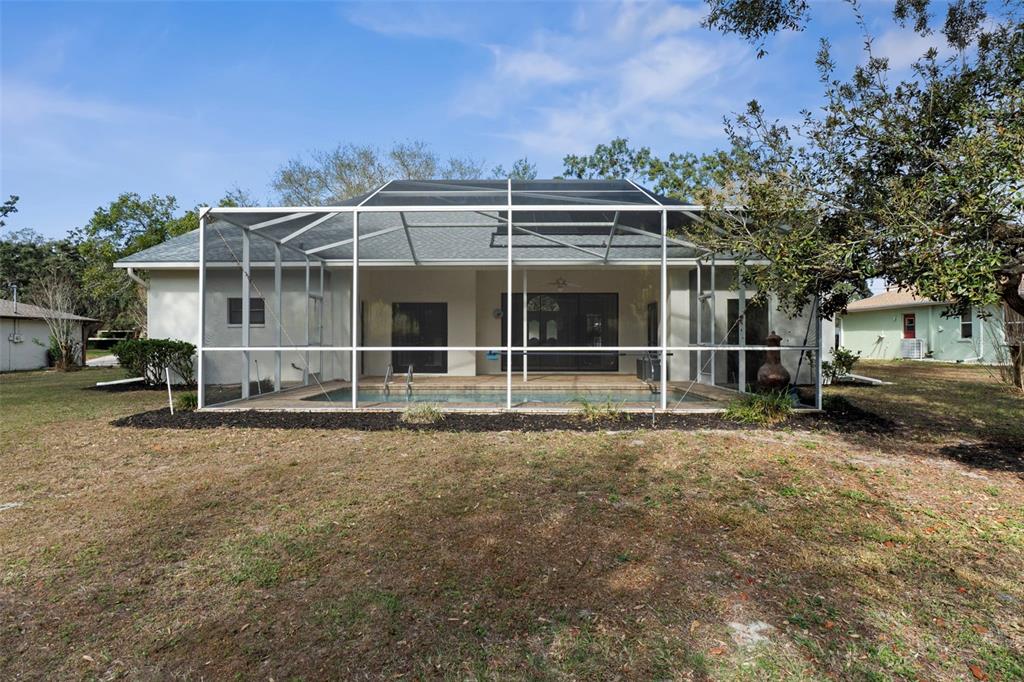 2214 Meadow Lark Road Spring Hill, FL 34608 - Photo 45 of 49 a view of a house with a yard and large trees