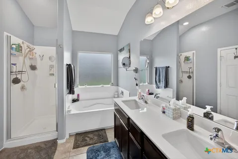 a bathroom with a sink a tub and a mirror