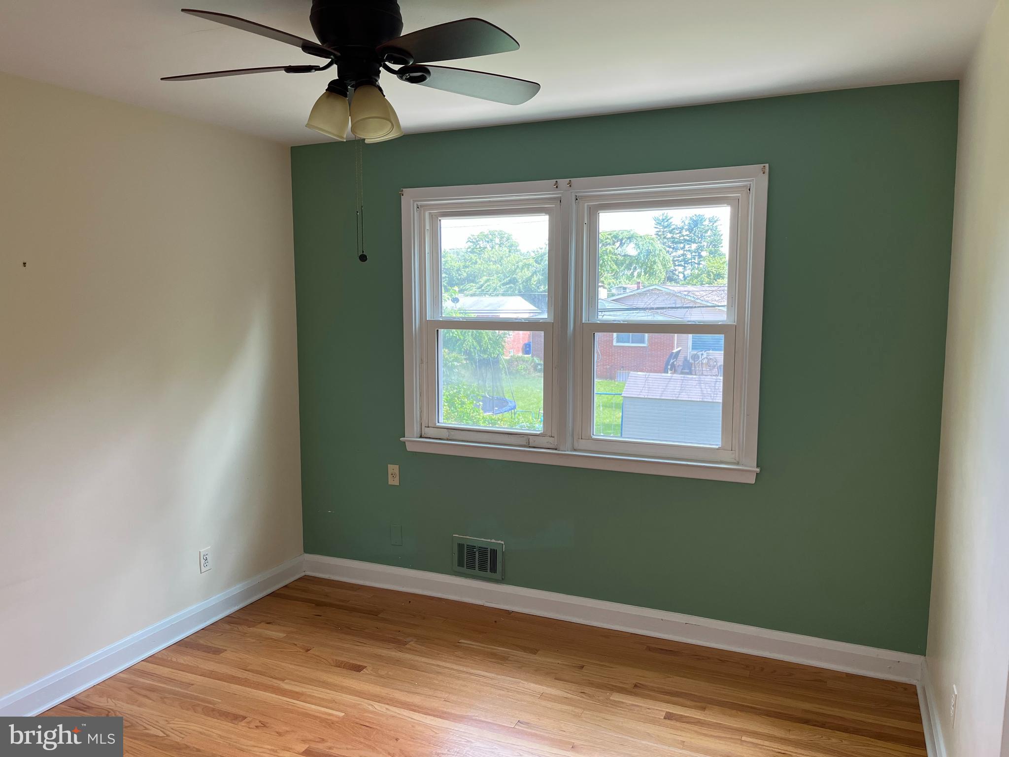 3109 Northbrook Road Baltimore, MD 21208 - Photo 12 of 23 an empty room with wooden floor fan and windows