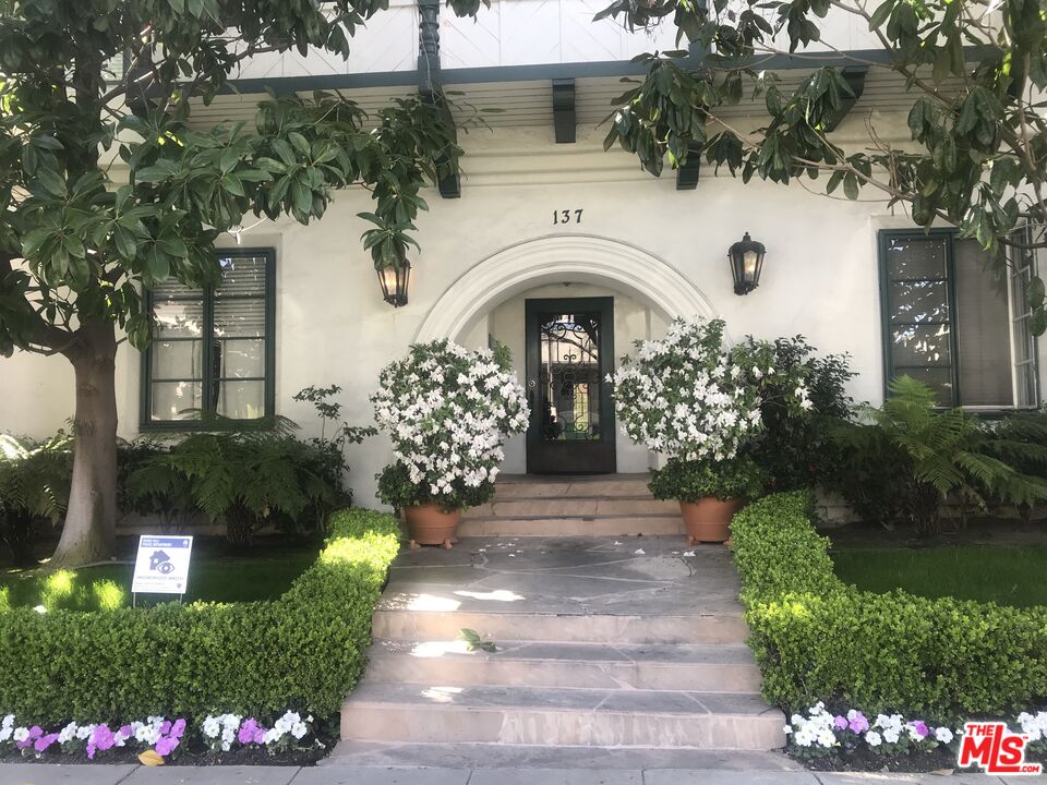a front view of a house with a garden