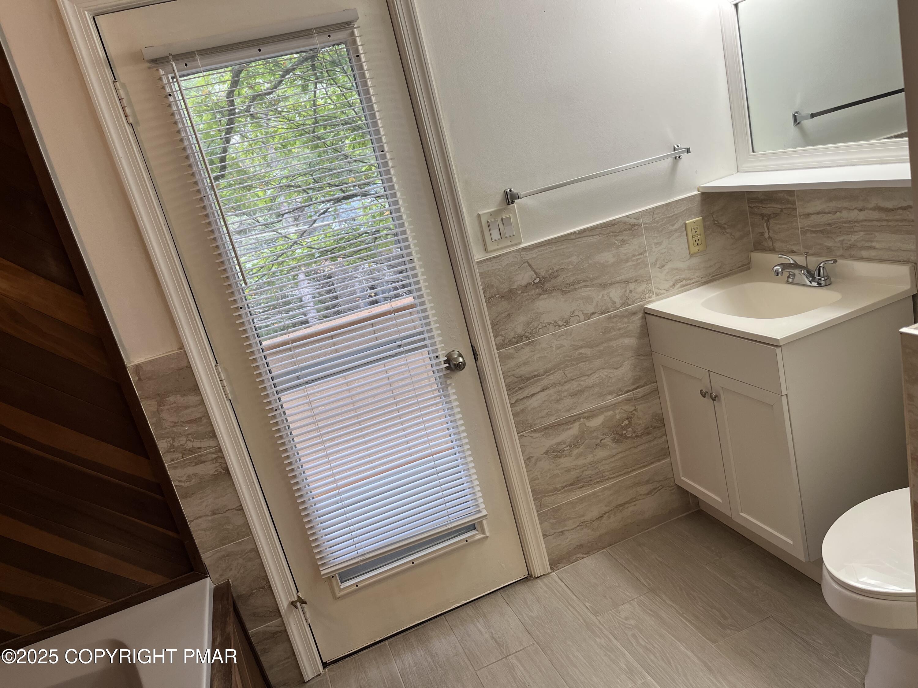 5031 Woodbridge Drive East Bushkill, PA 18324 - Photo 15 of 17 a bathroom with a sink a toilet a window and vanity