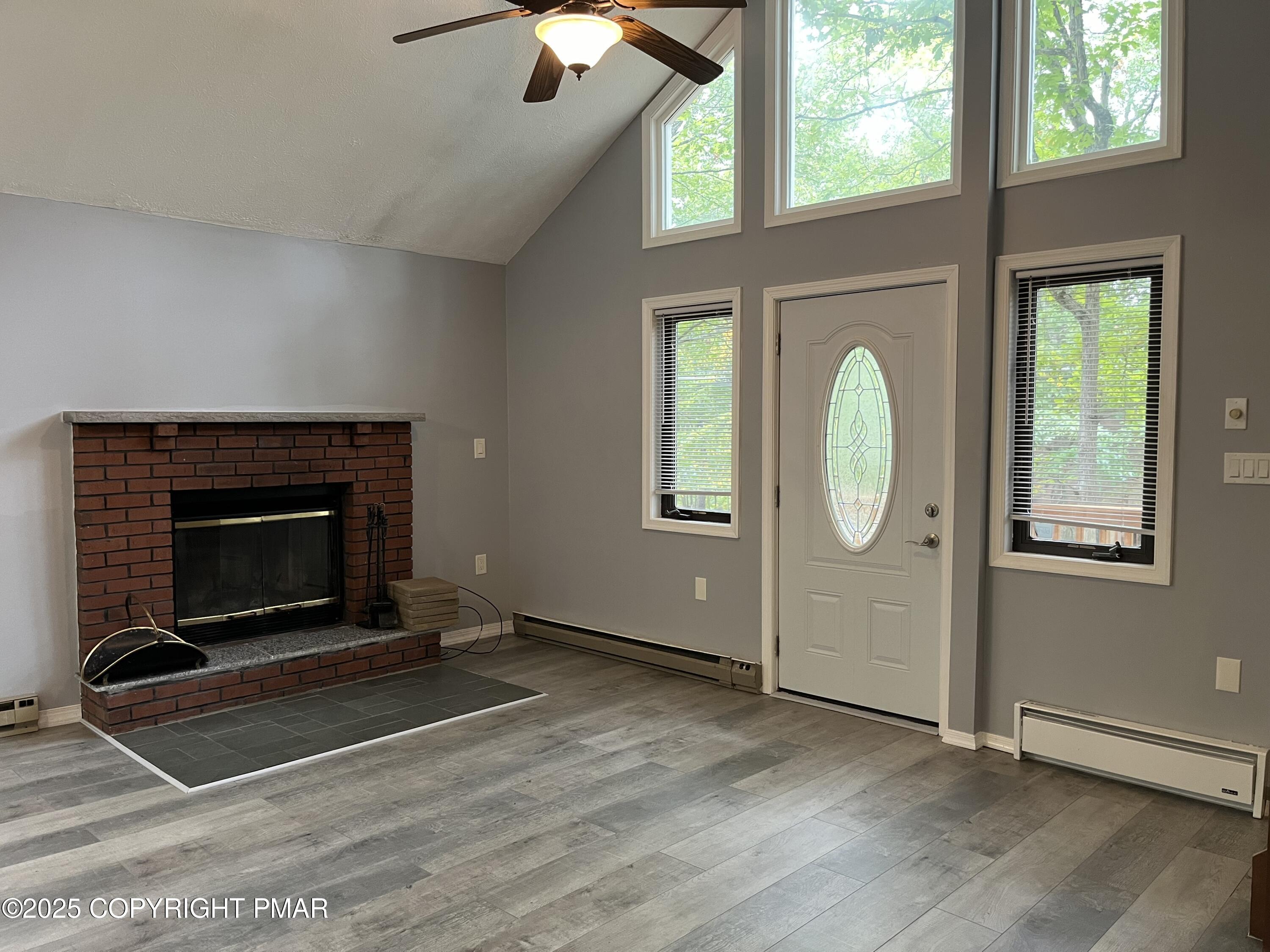 5031 Woodbridge Drive East Bushkill, PA 18324 - Photo 3 of 17 an empty room with wooden floor fireplace and windows